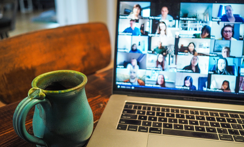 Laptopbeeldscherm met daarop de gezichten van collega's tijdens een online vergadering
